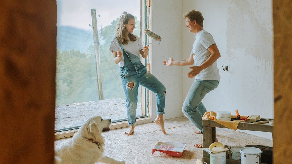 Pár tančící spolu se psem v novém domě – financování bydlení