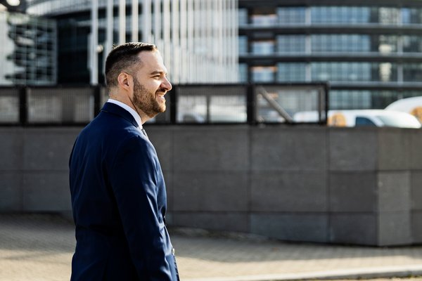 Muž stojící venku poblíž moderních budov.