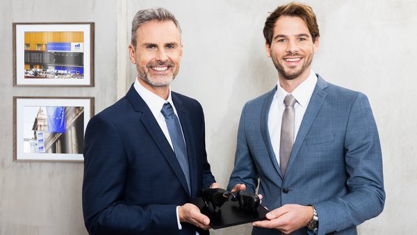 Dvě osoby stojící v interiéru.