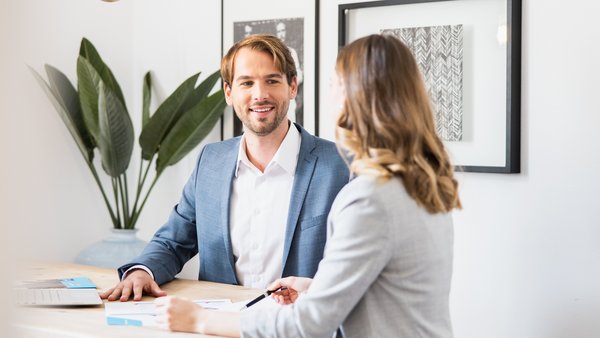 Muž a žena sedící u stolu během finanční konzultace.