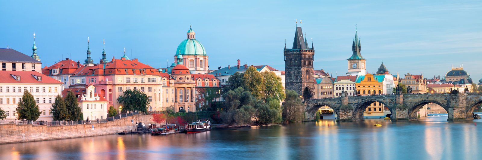 Pohled na město Praha Panorama města s historickými budovami a řekou s mostem