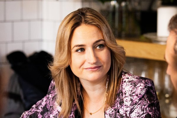 Žena sedící v interiéru, dívající se stranou.