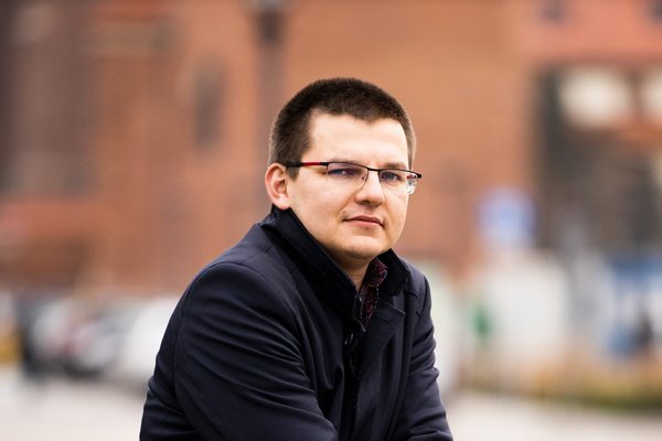 Muž stojící venku v městském prostředí.