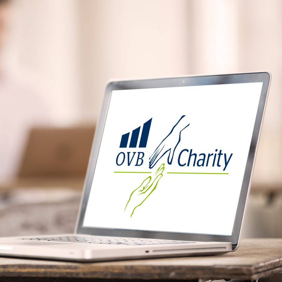 Společenská odpovědnost jako součást firemní identity Notebook s logem OVB Charity na obrazovce.