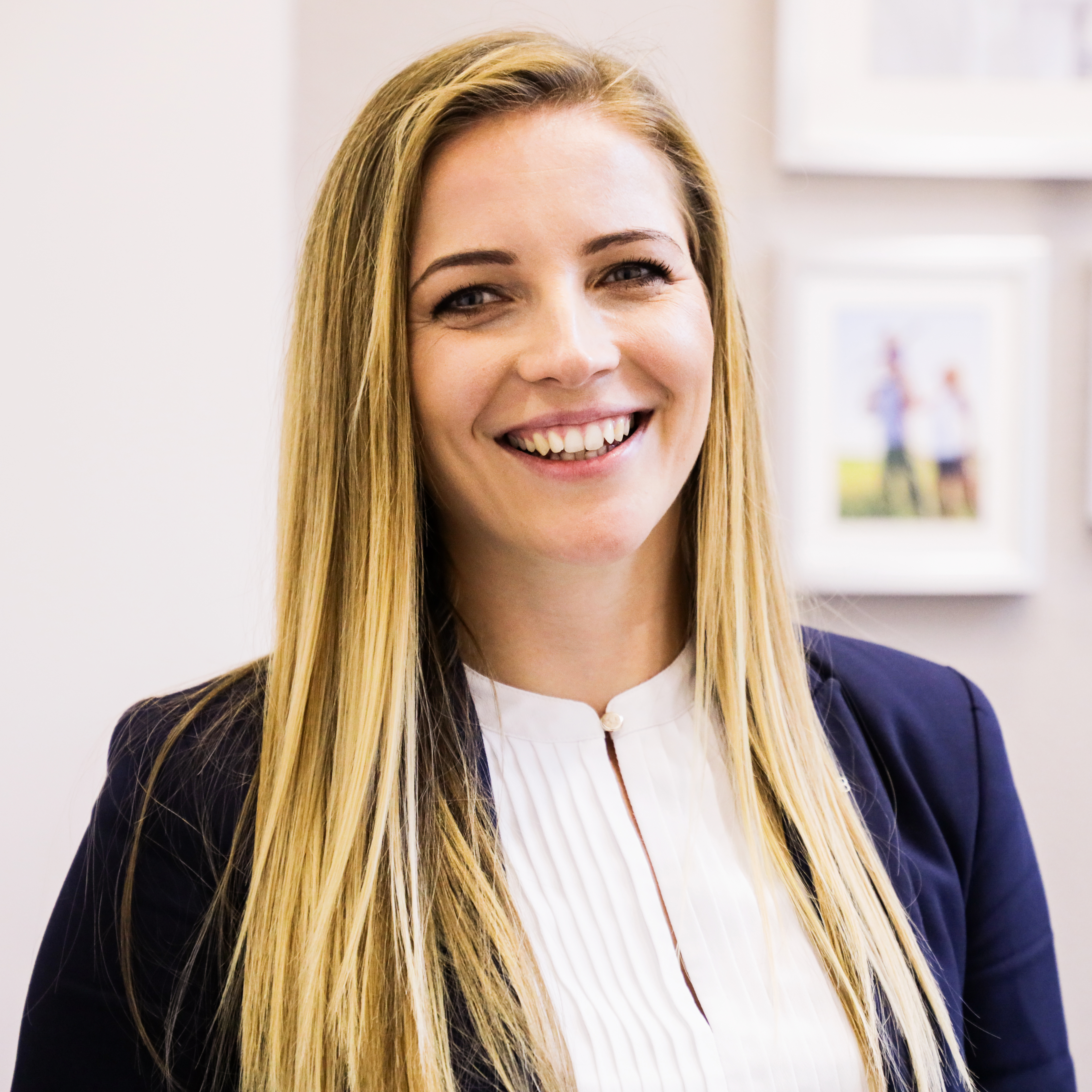 Žena usmívající se v profesionálním vnitřním prostředí.