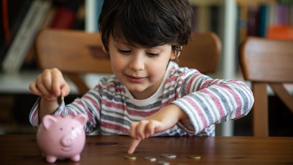 Dítě házející mince do spořícího prasátka – měsíční fixní náklady 