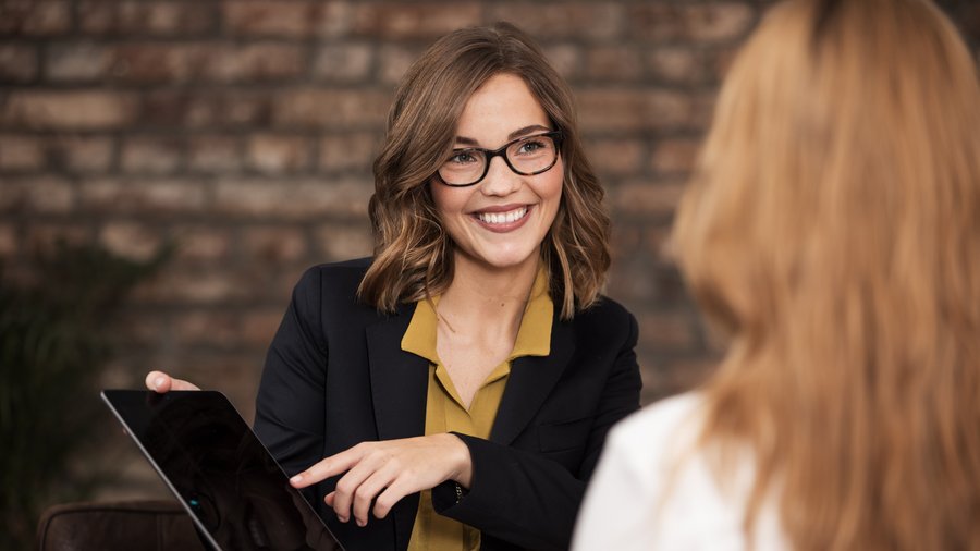 Dvě ženy sedící naproti sobě během rozhovoru v interiéru