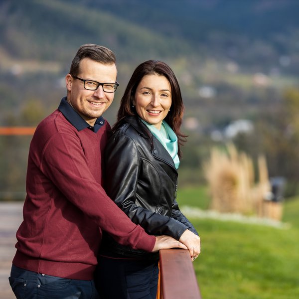 Muž a žena stojící venku a usmívající se.