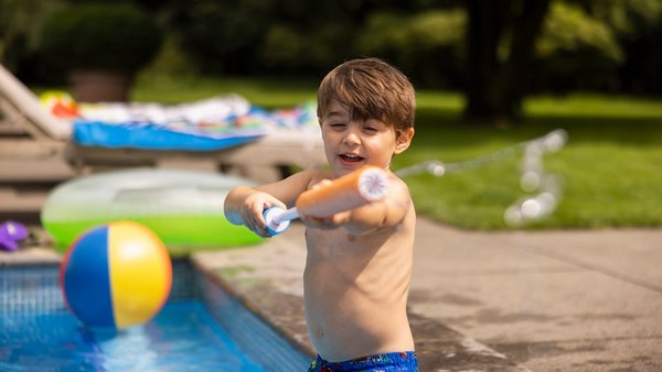 Dítě u bazénu s vodní pistolí – Cestujte bezpečně